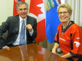 Premier Kathleen Wynne jokes that the Calgary Stampeders jersey is a little uncomfortable even if it is Liberal red, she prefers the Hamilton Ticats' black and yellow. (ANTONELLA ARTUSO/Toronto Sun)