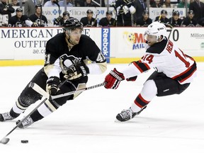 Pittsburgh Penguins defenseman Robert Bortuzzo (41) handles the puck against pressure from New Jersey Devils center Adam Henrique (14) during the first period at the CONSOL Energy Center on Dec 2, 2014. Charles LeClaire-USA TODAY Sports