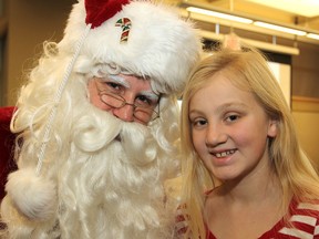 Santa Claus joins Devon Cobb as co-chair of this year's Tree of Hope Christmas Appeal by the Family and Children's Services of Frontenac, Lennox and Addington in Kingston. The appeal collects toys and donations. Devon has held her own toy drive for years. (Michael Lea/The Whig-Standard)