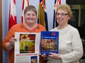 Bonnie Axcell, President of The Cochrane Royal Canadian Legion and Dorothy Smith Ladies' Auxiliary President pose with Ontario Command Military Service Recognition Book Volume 1 at the Cochrane Legion.