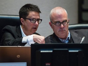 Ottawa City Council convened Dec. 3, 2014, for the first time with eight new members at the table. New member Catherine McKenney (left) and Jeff Leiper discuss a matter. (Errol McGihon/Ottawa Sun)