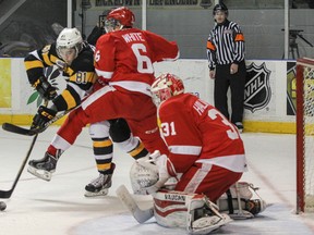 Kingston Frontenacs’ Conor McGlynn tries to knock the rolling puck past Sault Ste. Marie Greyhounds Colton White and goaltender Brandon Halverson but gets stopped during the second period of Ontario Hockey League action at the Rogers K-Rock Centre on Nov. 23. (Julia McKay/The Whig-Standard)