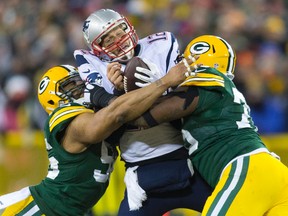 Patriots QB Tom Brady is sacked by two Green Bay Packers defenders. (USA TODAY SPORTS)