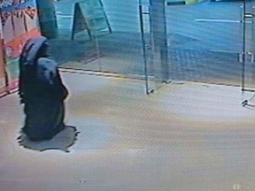 A person, dressed in a black robe and suspected in the killing of a U.S. woman at a shopping mall at Al Reem Island in Abu Dhabi is seen in this still image taken from a monitoring camera footage provided by Abu Dhabi Police on December 3, 2014.  REUTERS/Abu Dhabi Police/Handout via Reuters