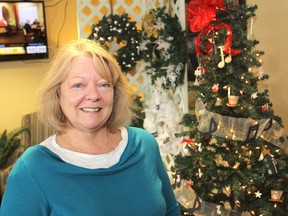 The Lung Association's April McCann stands in front of some of the wreaths and trees on display during the Festival of Trees. It runs through Dec. 12 at The Royale retirement residence on outer Princess Street. (Michael Lea/The Whig-Standard)