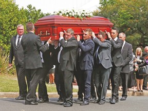Pallbearers for cricketer Phillip Hughes carry his coffin out of a funeral in his home town of Macksville, Australia, on Wednesday. (REUTERS)