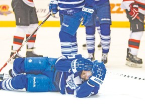 Phil Kessel holds his head after hitting the ice following his late third-period goal against the Devils on Thursday night. (ERNEST DOROSZUK/Toronto Sun)