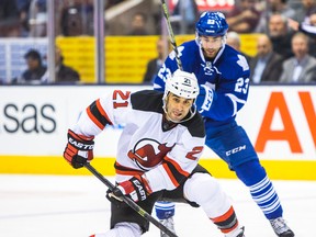 Devils’ Scott Gomez attempts to corral the puck as Maple Leafs’ Trevor Smith is hot on his trail on Thursday night at the Air Canada Centre. Journeyman Gomez was recently signed by his former team. (Ernest Doroszuk/Toronto Sun)