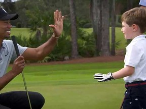 Tiger Woods gives Tommy Morrissey a high five. (YouTube screengrab)