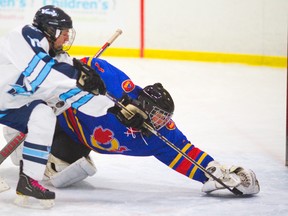 Oakridge goalie Jordan Warner stretches back to cover the puck and the blade of Lucas forward Adam Keyes? stick to keep the Vikings at bay early in their TVRA Central boys hockey game Friday at Stronach arena. Warner shut the Vikings out until the third period as the Oaks won 5-3. (MIKE HENSEN, The London Free Press)