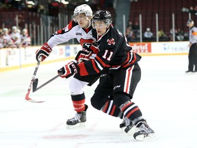 Ottawa 67's defencemen Alex Lintuniemi battles with Niagara's Brenden Perlini during the first period of a game against the IceDogs at TD Place on Friday, Dec. 5, 2014. (Chris Hofley/Ottawa Sun)