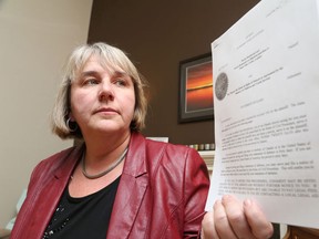 Nicole Desmarais shows off a document of a lawsuit she has filed against the Ontario Ministry of Child and Youth Services seeking to have the province cover the cost of treatment for her adopted son, whom she wants to see get specialized care for two severe mental illnesses. (Gino Donato/QMI Agency)