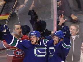 Daniel Sedin of the Vancouver Canucks (right) celebrates his overtime goal against the Montreal Canadiens on Oct. 30, 2014, with his brother Henrik Sedin. (CARMINE MARINELLI/QMI Agency files)