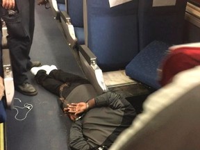 A man is seen in custody aboard an Amtrak train following a stabbing incident in Niles, Michigan December 5, 2014.  A suspect was taken into custody by police in Michigan on Friday after multiple victims were stabbed aboard an Amtrak train in the small city of Niles, a police dispatcher said.  (REUTERS/Chris Maynard/Handout via Reuters)