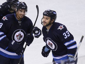Winnipeg Jets defenceman Dustin Byfuglien (right) celebrates his third-period goal against the Colorado Avalanche with Evander Kane during NHL action at MTS Centre in Winnipeg, Man., on Fri., Dec. 5, 2014. Kevin King/Winnipeg Sun/QMI Agency