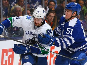 Jake Gardiner #51 of the Toronto Maple Leafs holds up Brad Richardson #15 of the Vancouver Canucks during NHL action at the Air Canada Centre February 8, 2013 in Toronto, Ontario, Canada.  Abelimages/Getty Images/AFP