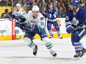 Canucks’ Bo Horvat skates up the ice with the Maple Leafs’ Trevor Smith at the Air Canada Centre last night. (AFP)