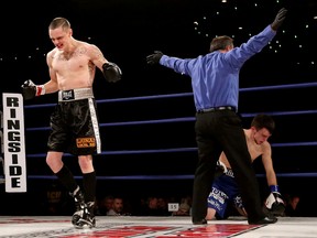 Mike McWilliams, left, celebrates after knocking down Reese Chapman during the Attack and Conquer boxing event at the Shaw Conference Centre, in Edmonton on Friday. (David Bloom, Edmonton Sun)