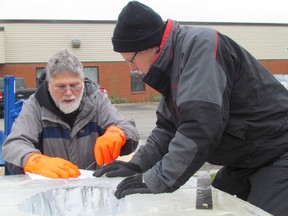 Snowfest volunteers Jim Vergunst, left, and Gary Heather do the math to convert a drawing to an ice sculpture for a Christmas parade float. NEIL BOWEN/ THE OBSERVER/ QMI AGENCY