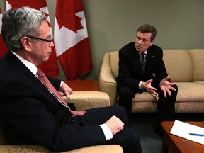 Toronto Mayor John Tory, right, sits down with federal Finance Minister Joe Oliver in Toronto on Friday, December 5, 2014. (Craig Robertson/Toronto Sun)