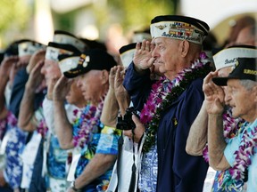 Louis Conter (3rd R in blue jacket), a USS Arizona survivor, and other Pearl Harbor survivors salute as the USS Chung-Hoon passes by during ceremonies honoring the 73rd anniversary of the attack on Pearl Harbor at the World War II Valor in the Pacific National Monument in Honolulu, Hawaii December 7, 2014. More than 50 World War Two veterans will gather in Honolulu on Sunday to commemorate the 73rd anniversary of the Japanese attack on Pearl Harbor that left more than 2,000 Americans dead and thrust the United States into the war. REUTERS/Hugh Gentry
