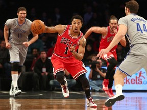 Chicago Bulls point guard Derrick Rose (1) dribbles the ball in front of Brooklyn Nets center Brook Lopez (11) and shooting guard Bojan Bogdanovic (44) during the first quarter at Barclays Center on Nov 30, 2014; Brooklyn, NY, USA. (Brad Penner/USA TODAY Sports)