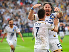 Galaxy forward Robbie Keane (left) celebrates with forward Alan Gordon (right) after scoring a goal against the New England Revolution  in the overtime during the  MLS Cup final at Stubhub Center. ( Gary A. Vasquez-USA TODAY Sports)