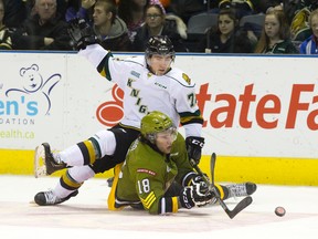 North Bay Battalion forward Mike Amadio is dumped to the ice by London Knights forward Aaron Berisha during their OHL game at Budweiser Gardens on Sunday. The Knights rallied to win 5-4 in overtime. (CRAIG GLOVER, The London Free Press)