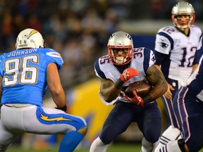 \New England Patriots running back Jonas Gray (35) runs as San Diego Chargers outside linebacker Jarret Johnson (96) defends as Patriots quarterback Tom Brady (12) looks on during the first quarter at Qualcomm Stadium on Dec 7, 2014 in San Diego, CA, USA. (Jake Roth/USA TODAY Sports)