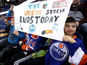 Right to left: Chris Meneses, 10, Brandon Barbosa, 14, and Benjamin Meneses, 7, cheer on the Edmonton Oilers prior to the start of their game against the San Jose Sharks at Rexall Place, in Edmonton Alta., on Sunday Dec. 7, 2014. David Bloom/Edmonton Sun