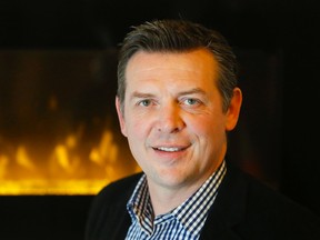 Former Calgary Flames hockey star Theo Fleury stands in front of the fireplace at the Banquet Centre in Belleville, Ont. Monday, Dec. 8, 2014. The sexual assault survivor turned author and occupational therapist Kim Barthel spent the day discussing recovery from trauma, including that caused by sexual assault.