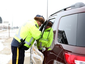 A member of the RCMP speaks with a driver during a Checkstop along Highway 59 earlier this month. (Brook Jones/QMI Agency file photo)