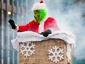 The grinch waves from inside a smoking chimney that was part of the Duraroc Rubber Surfacing float in the St. Catharines Santa Claus Parade on Saturday, November 22, 2014. Julie Jocsak/QMI Agency