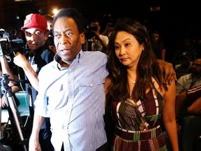 Brazilian soccer legend Pele and his girlfriend Marcia arrive for a news conference in Sao Paulo December 9, 2014. (REUTERS)