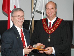 David Marr, Central Elgin mayor and Elgin county warden for 2014, hands a gavel and watch to Bayham mayor and warden for 2015 Paul Ens at the county administration building on Tuesday, Dec. 9, 2014. Ens was acclaimed to the post. (Ben Forrest, Times-Journal)