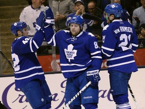 Maple Leafs’ Phil Kessel (right) high fives Tyler Bozak after scoring an empty-net goal against the    Flames’ last night. It was Kessel’s third goal in his past four games. (Craig Robertson/Toronto Sun)