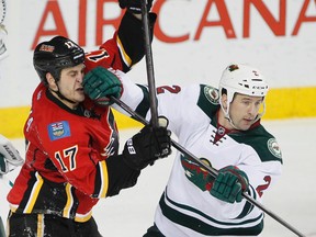 Keith Ballard of the Minnesota Wild (right) elbows Lance Bouma of the Calgary Flames in the face during NHL action in Calgary February 1, 2014.  (LYLE ASPINALL /QMI Agency)