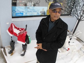 Stinson gas station owner Romeo Dipchand stands next to what is left of the Santa Claus that was in front of his store before thieves made off with it early Wednesday. (Elliot Ferguson/The Whig-Standard)