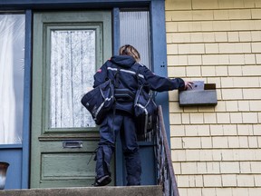 A letter carrier for Canada Post delivers mail to a residential neighbourhood  in Vancouver. 
(File Photo)