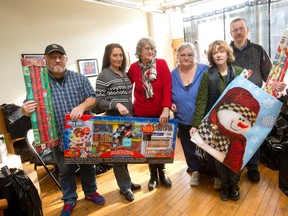 Life*Spin executive director Jacqueline Thompson, second right, and volunteers Shawn Edwards, left, Joanne Misselbrook, Patricia Runciman, Deb Ratz, and Darryl Edwards ready gifts for London-area families at their Dundas St. office Wednesday. (CRAIG GLOVER / The London Free Press)
