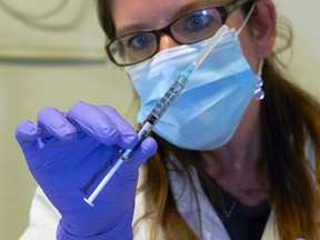 A nurse holds a syringe containing an experimental Ebola virus vaccine during a media visit at the Lausanne University Hospital (CHUV) in Lausanne in this November 4, 2014 file photo. (REUTERS/Denis Balibouse/Files)