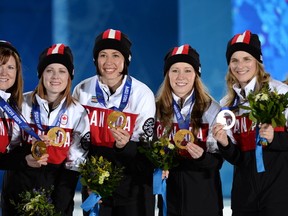 (From left) Canadian gold medallists Kirsten Wall, Dawn McEwen, Jill Officer, Kaitlyn Lawes and Jennifer Jones celebrate during the Women's Curling Medal Ceremony at the Sochi medals plaza during the Sochi Winter Olympics. The rink has been nominated as Manitoba's team of the year. (AFP FILE PHOTO/PETER PARKS)