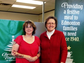 Christmas Bureau Edmonton executive director Wendy Batty (right) and a former client, Carla (no last name given), stand behind a food hamper. Click here to help out the Christmas Bureau (SUPPLIED)