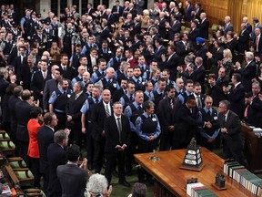 House of Commons security guards receive a standing ovation from Members of Parliament during a special ceremony in Ottawa, Dec. 11, 2014. (CHRIS WATTIE/Reuters)