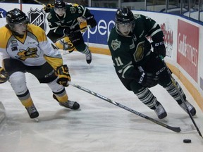 Owen MacDonald of the London Knights protects the puck from Sarnia Sting defenceman Jeff King during OHL action at RBC Centre in Sarnia Thursday night. It was the first meeting of the season between the two OHL clubs.(TERRY BRIDGE, The Observer)