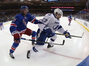 John Moore of the New York Rangers checks Jonathan Drouin of the Tampa Bay Lightning during the first period at Madison Square Garden on December 1, 2014. (Bruce Bennett/Getty Images/AFP)