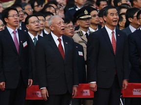 (From L) Zhang Xiaoming, Director of the Liaison Office of the Central People's Government in Hong Kong, former Hong Kong Chief Executive Tung Chee-hwa and Hong Kong Chief Executive Leung Chun-ying sing national anthem during a flag raising ceremony in Hong Kong October 1, 2014, celebrating the 65th anniversary of China National Day.    REUTERS/Bobby Yip