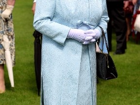 Britain's Queen Elizabeth smiles as she meets guests during a garden party held at Buckingham Palace, in central London June 10, 2014.  REUTERS/John Stillwell/Pool