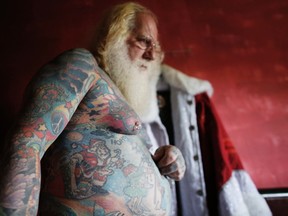 Vitor Martins displays one of his Christmas tattoos inside his house, before a Santa performance with children. (REUTERS/Nacho Doce)