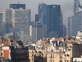 A view shows city rooftops and chimney stacks of residential apartment buildings in Paris with the financial district of La Defense in the background December 9, 2014.    REUTERS/Charles Platiau